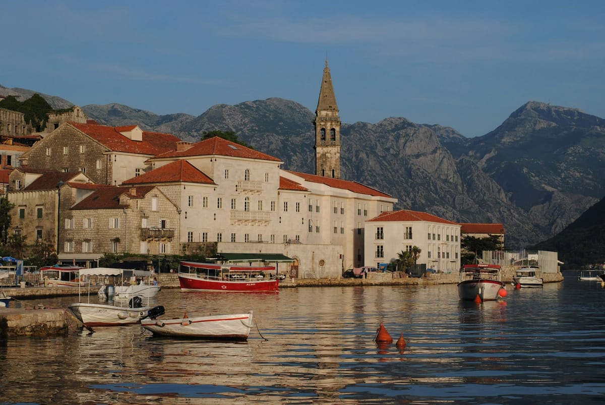 Warm evening light on the stone waterfront and bell tower of Perast, Montenegro