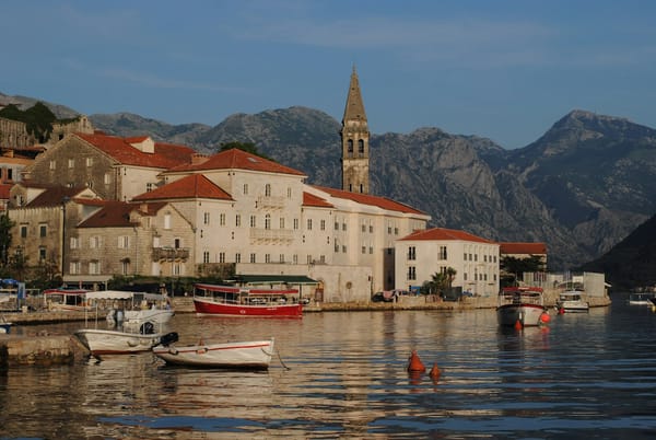 Warm evening light on the stone waterfront and bell tower of Perast, Montenegro